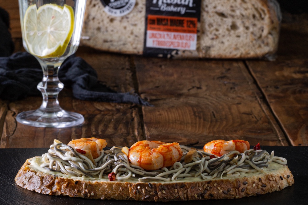 Tosta de gulas, gambas y alioli para una cena de altura